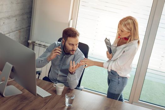 Young business colleagues arguing at the office.