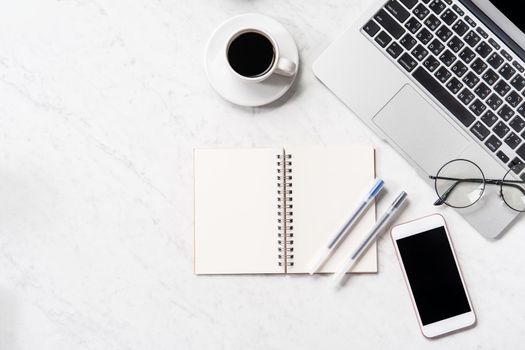 Stylized marble office working desk with smartphone, laptop, glasses and coffee, workspace design, mock up, topview, flatlay, copyspace, closeup