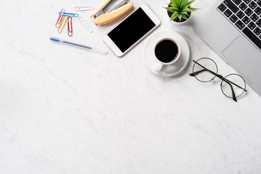 Stylized marble office working desk with smartphone, laptop, glasses and coffee, workspace design, mock up, topview, flatlay, copyspace, closeup