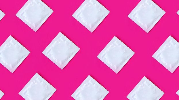Many condoms in rows on pink background, collection, composition of condoms