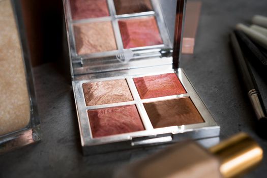 Eye shadow palette in rose gold and nude colors closeup. Makeup cosmetics. Selective focus.