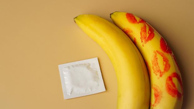 Condoms and two bananas with traces of red lipstick, concept of contraceptives and the prevention of venereal diseases.