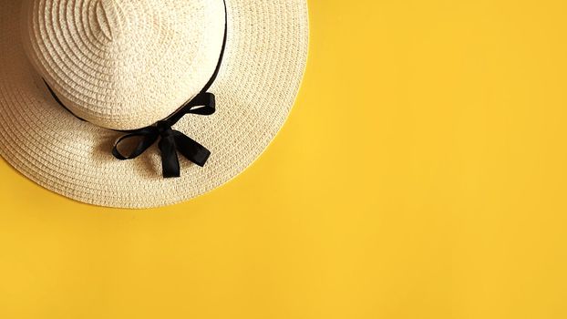 Summer straw hat on yellow background top view flat lay copy space. Summer travel vacation concept, single item. Female accessory, summer background