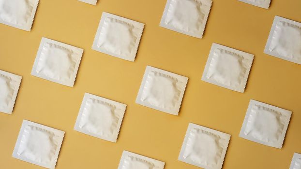 Many condoms in rows on golden background, collection, composition of condoms