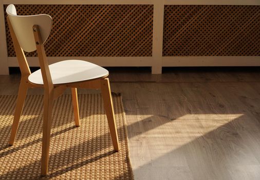 Scandinavan modern interior. White chair in room. Sunlight from window