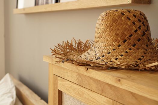 Straw hat on the shelf in room in a Scandinavian style. Soft light