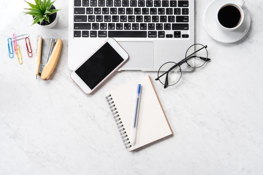 Stylized marble office working desk with smartphone, laptop, glasses and coffee, workspace design, mock up, topview, flatlay, copyspace, closeup