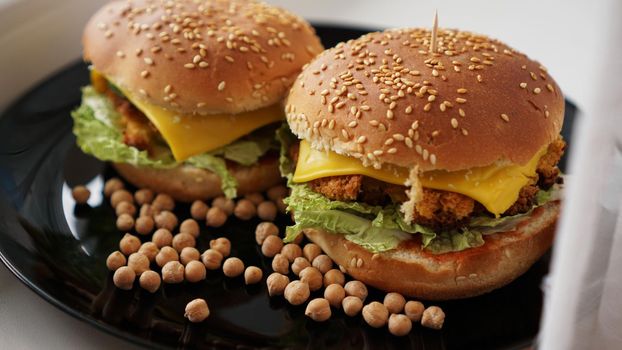 Vegetable Burger with chickpea cutlet. Two burgers on a black plate