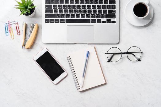 Stylized marble office working desk with smartphone, laptop, glasses and coffee, workspace design, mock up, topview, flatlay, copyspace, closeup