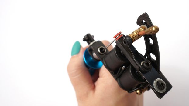 Tattoo machine on tattoo artist hand isolated on white background