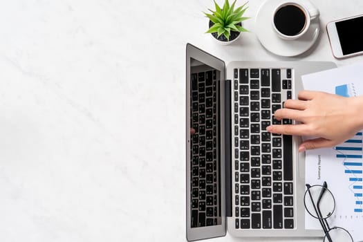 A woman is doing a online payment or shopping, mock up credit card and mobile phone on office desk isolated on beautiful fashion marble background, topview, flatlay, copyspace.