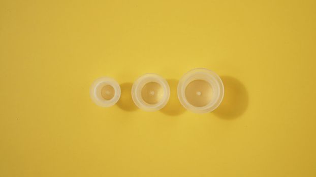 Three ink plastic caps on yellow background - tattoo concept