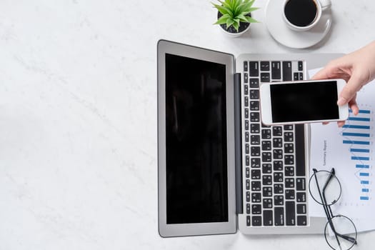 A woman is doing a online payment or shopping, mock up credit card and mobile phone on office desk isolated on beautiful fashion marble background, topview, flatlay, copyspace.