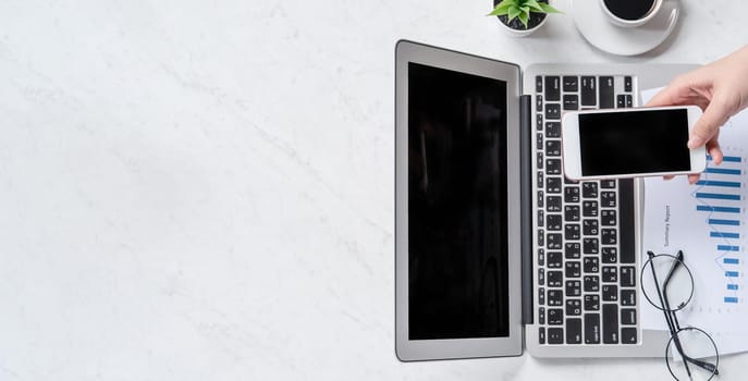 A woman is doing a online payment or shopping, mock up credit card and mobile phone on office desk isolated on beautiful fashion marble background, topview, flatlay, copyspace.