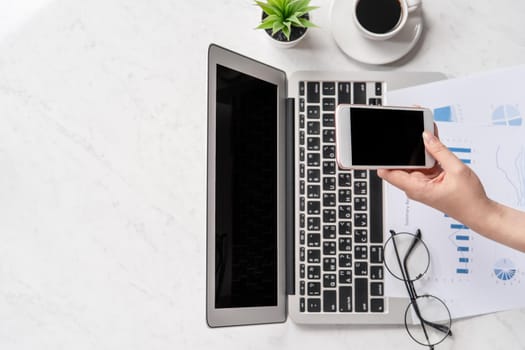 A woman is doing a online payment or shopping, mock up credit card and mobile phone on office desk isolated on beautiful fashion marble background, topview, flatlay, copyspace.