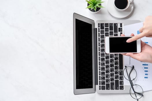 A woman is doing a online payment or shopping, mock up credit card and mobile phone on office desk isolated on beautiful fashion marble background, topview, flatlay, copyspace.
