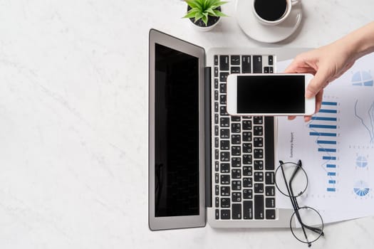 A woman is doing a online payment or shopping, mock up credit card and mobile phone on office desk isolated on beautiful fashion marble background, topview, flatlay, copyspace.