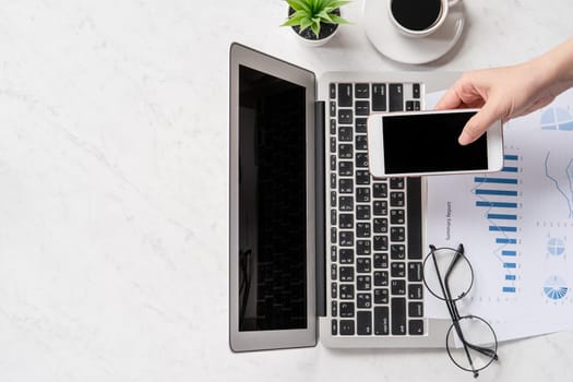A woman is doing a online payment or shopping, mock up credit card and mobile phone on office desk isolated on beautiful fashion marble background, topview, flatlay, copyspace.