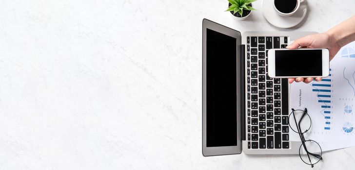 A woman is doing a online payment or shopping, mock up credit card and mobile phone on office desk isolated on beautiful fashion marble background, topview, flatlay, copyspace.