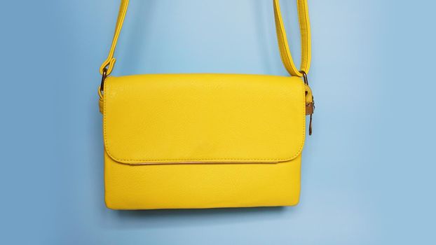 Yellow fashion female woman purse handbag on blue background