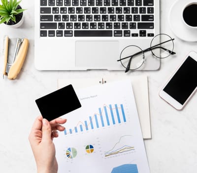 Online bill payment concept, a woman using mock up credit card and mobile cell phone on office desk isolated on beautiful fashion marble background, copy space, topview, flatlay, closeup