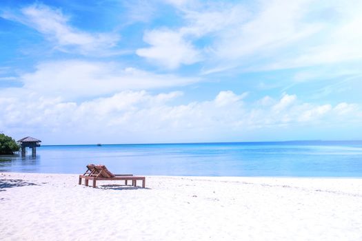 Chairs on the amazing beautiful sandy beach near the ocean with blue sky. Concept of summer leisure calm vacation for a tourism idea. Empty copy space, inspiration of tropical landscape