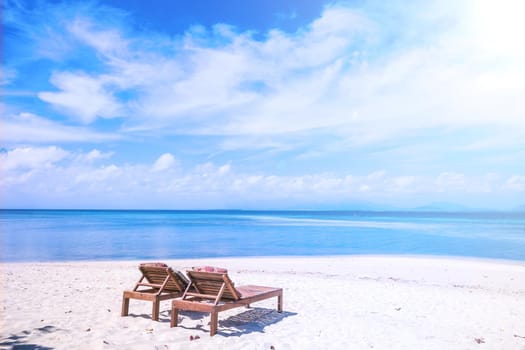 Chairs on the amazing beautiful sandy beach near the ocean with blue sky. Concept of summer leisure calm vacation for a tourism idea. Empty copy space, inspiration of tropical landscape