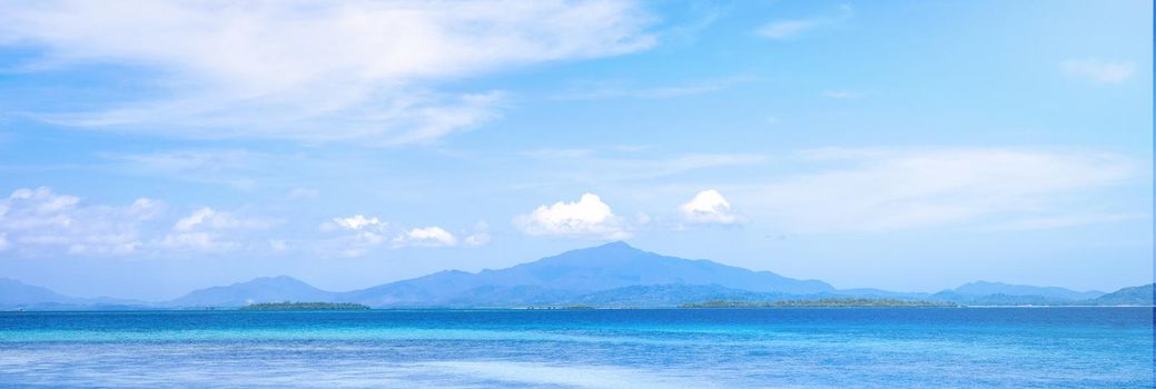Beautiful ocean scene view isolated with light blue sky background, concept of vacation and sea travel, copy space