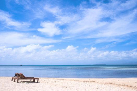 Chairs on the amazing beautiful sandy beach near the ocean with blue sky. Concept of summer leisure calm vacation for a tourism idea. Empty copy space, inspiration of tropical landscape