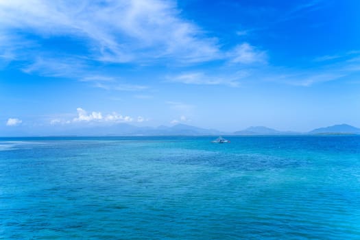 Beautiful ocean scene view isolated with light blue sky background, concept of vacation and sea travel, copy space