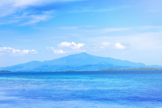 Beautiful ocean scene view isolated with light blue sky background, concept of vacation and sea travel, copy space