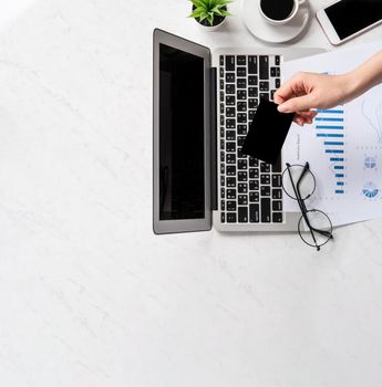 Concept of a woman is doing a online purchase, mock up card and cellphone on office desk isolated on beautiful fashion marble background, copy space, top view, flat lay, closeup