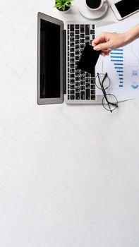 Concept of a woman is doing a online purchase, mock up card and cellphone on office desk isolated on beautiful fashion marble background, copy space, top view, flat lay, closeup