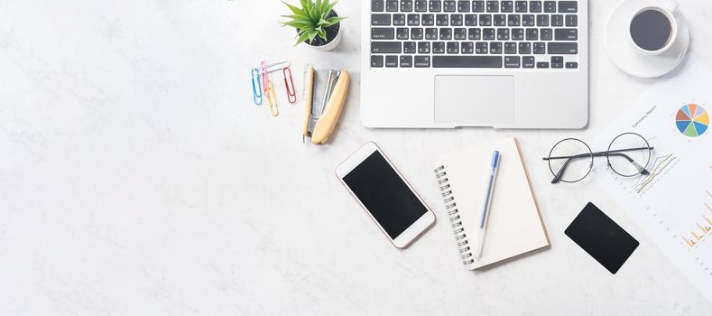 Stylized clean marble office working desk with smartphone, laptop, glasses and coffee, workspace design, mock up, top view, flat lay, copy space, closeup
