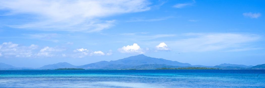 Beautiful ocean scene view isolated with light blue sky background, concept of vacation and sea travel, copy space