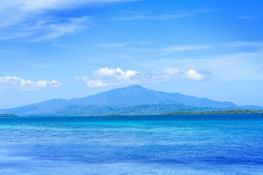 Beautiful ocean scene view isolated with light blue sky background, concept of vacation and sea travel, copy space