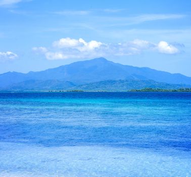 Beautiful ocean scene view isolated with light blue sky background, concept of vacation and sea travel, copy space