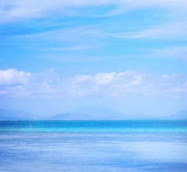 Beautiful ocean scene view isolated with light blue sky background, concept of vacation and sea travel, copy space