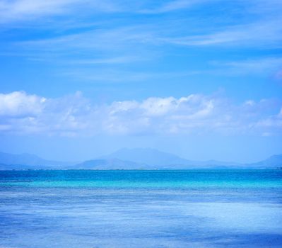 Beautiful ocean scene view isolated with light blue sky background, concept of vacation and sea travel, copy space