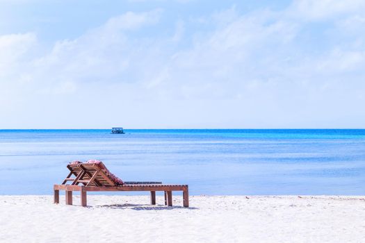 Chairs on the amazing beautiful sandy beach near the ocean with blue sky. Concept of summer leisure calm vacation for a tourism idea. Empty copy space, inspiration of tropical landscape