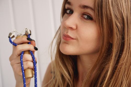 Skipping rope. Portrait of an attractive young sporty woman holding a skipping rope while standing over white background