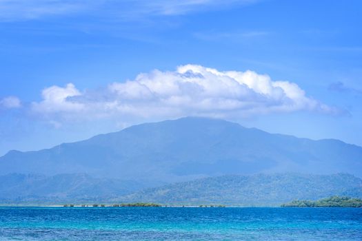 Beautiful ocean scene view isolated with light blue sky background, concept of vacation and sea travel, copy space
