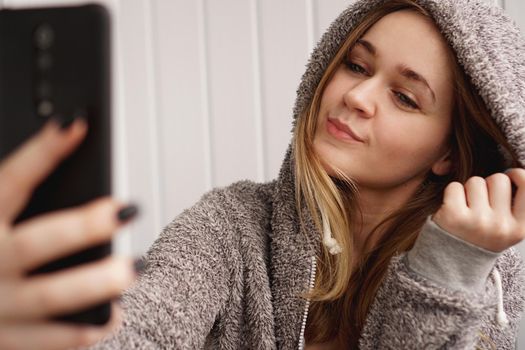 Picture of young happy emotional pretty lady indoors. Looking camera make selfie