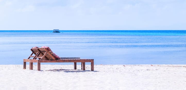 Chairs on the amazing beautiful sandy beach near the ocean with blue sky. Concept of summer leisure calm vacation for a tourism idea. Empty copy space, inspiration of tropical landscape