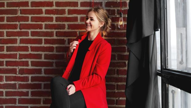 Businesswoman happy smile wear red jacket - business woman over office brick wall