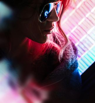 Portrait of the Beautiful Young Pro Gamer Girl. Attractive Girl with Glasses by Neon Lights.