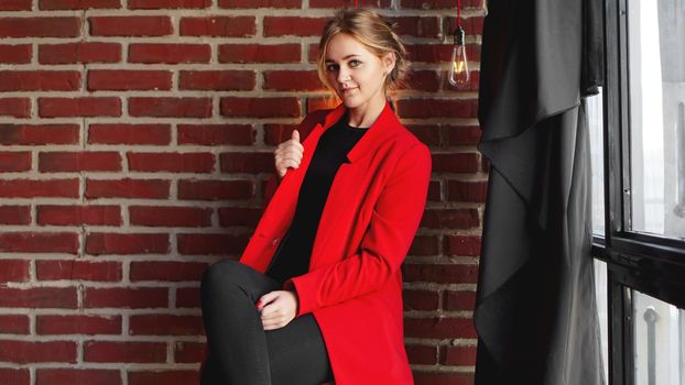 Businesswoman happy smile wear red jacket - business woman over office brick wall