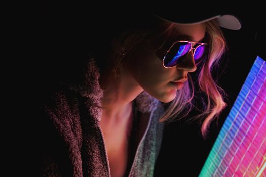 Portrait of the Beautiful Young Pro Gamer Girl. Attractive Girl with Glasses by Neon Lights.