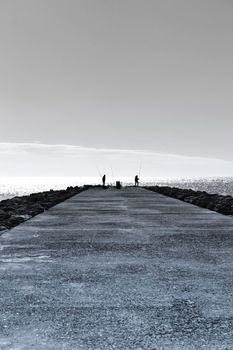Fishing day on a breakwater under the sun in Santa Pola, Spain