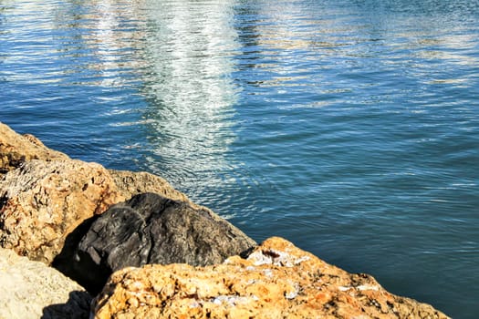 Reflections in the sea and rocks under the sun in Santa Pola, Spain
